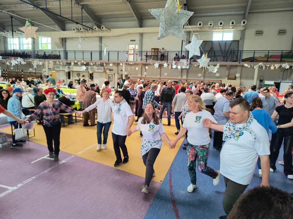 Uczestnicy ŚDS w Wejherowie tańczą wspólnie w hali sportowej podczas integracyjnego wyjazdu do Chmielna